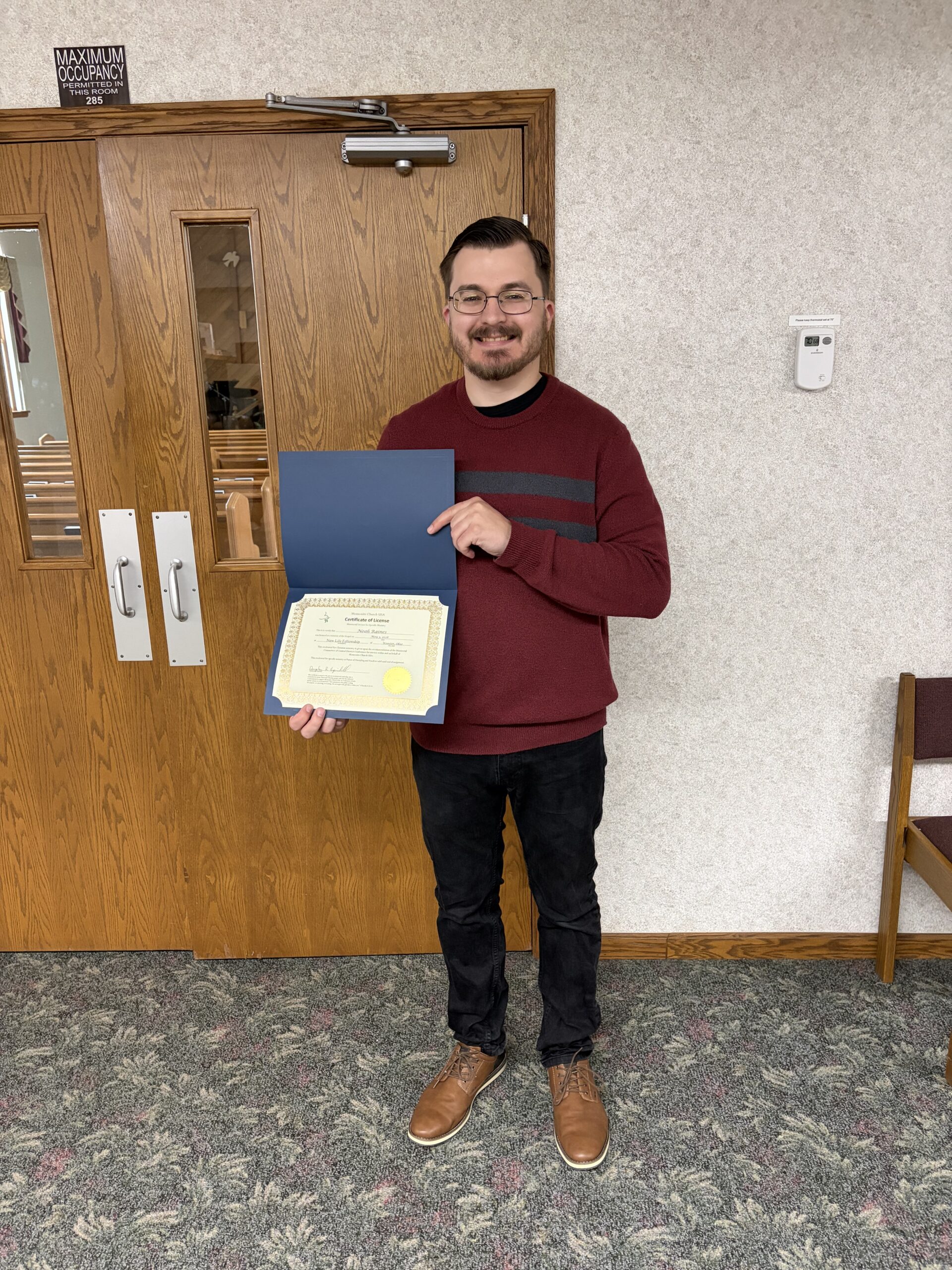 Pastor Noah Raines holding his ministerial licensing certificate.
